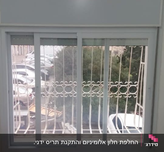 חלון אלומיניום עם מסגרת לבנה ותריסים